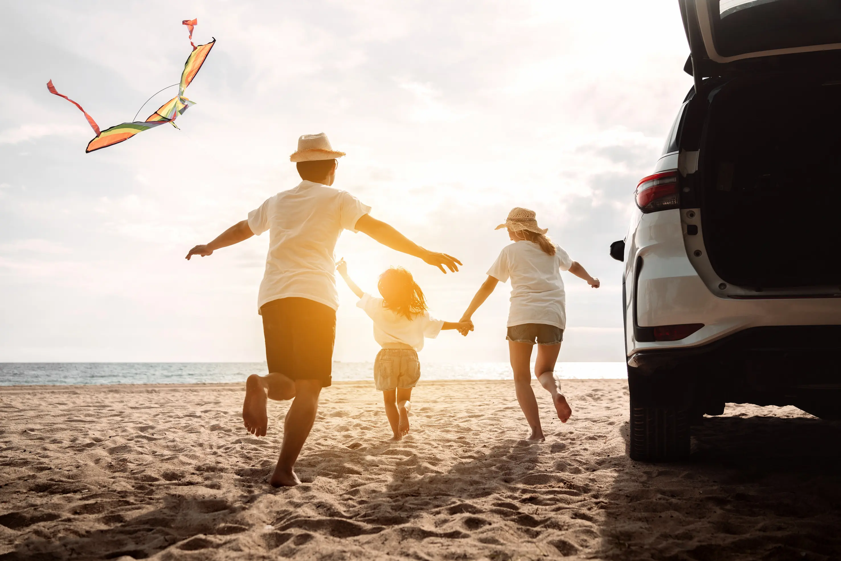 Family playing with kite on the beach